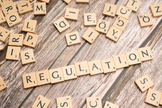 Wooden letter tiles spelling 'Regulation' on a textured wood background, conveying themes of compliance and structure. The section 21 and FCA approval checks to run before comparing finance creator agencies